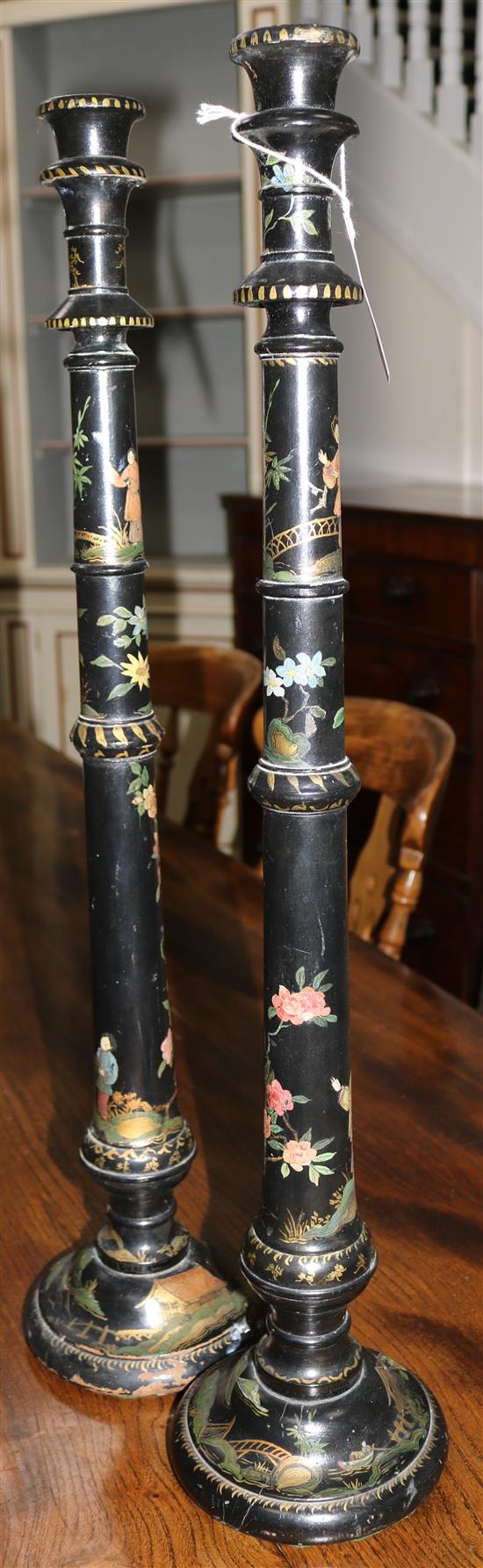 A pair of tall lacquered lamp standards